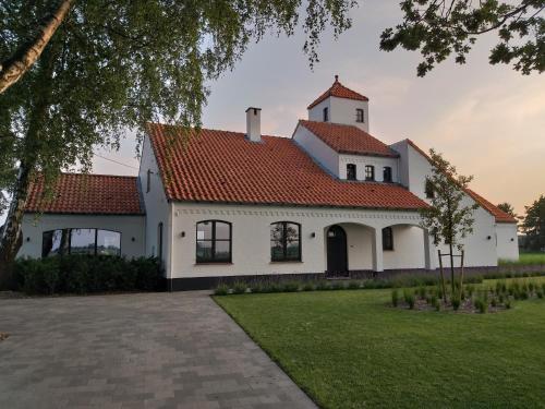 a white house with a red roof at Landhuys Odette in Retie
