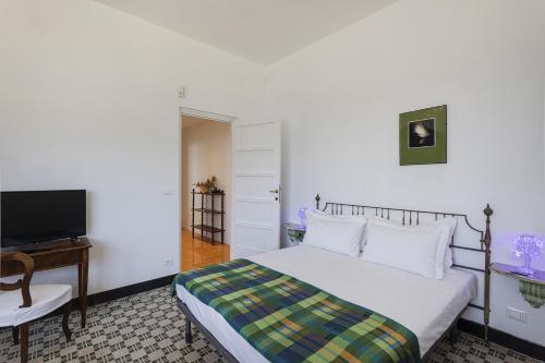 a bedroom with a bed and a desk and a television at A Few Steps from the Sea by Wonderful Italy in Recco