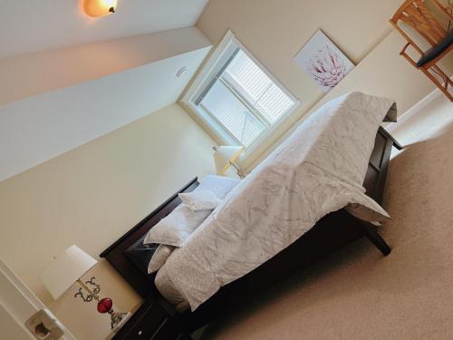um pequeno quarto com uma cama e uma janela em Peaceful and Spacious Lake View em West Kelowna
