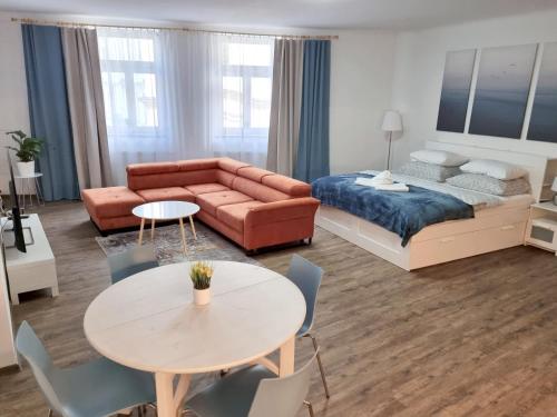 ein Wohnzimmer mit einem Sofa, einem Bett und einem Tisch in der Unterkunft Luxusní apartmán na Velkém náměstí in Hradec Králové