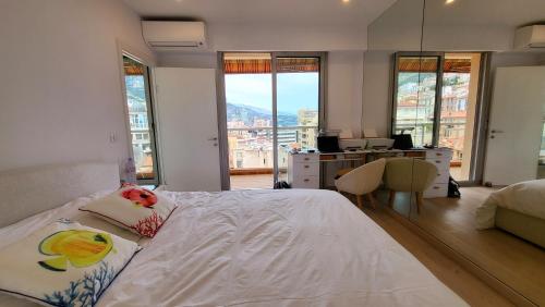 a bedroom with a bed and a desk and windows at PENTHOUSE MAJESTIC, MC, Bnbrickeys in Monte Carlo