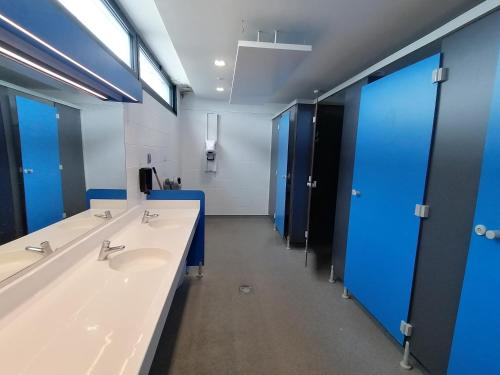 a bathroom with two sinks and blue stalls at Séjour insolite sur un yacht. Bateau Hôtel à quai. in La Rochelle