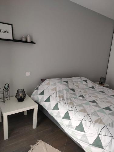 - une chambre avec un lit et une table de chevet dans l'établissement Appartement aux Minimes, à La Rochelle