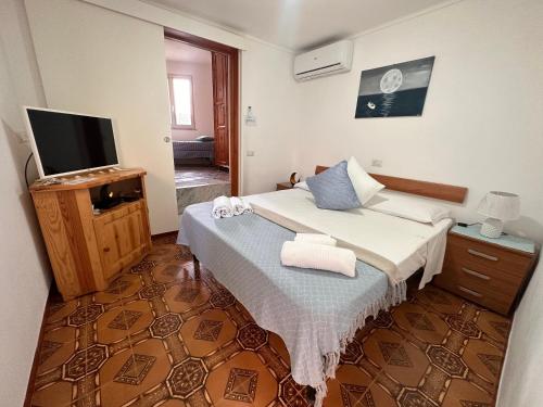 a bedroom with a bed and a television in it at Casa Mezzaluna in Ponza