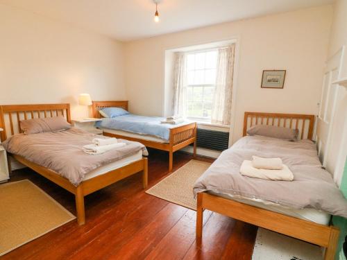 um quarto com 2 camas individuais e uma janela em Covercote em Leyburn