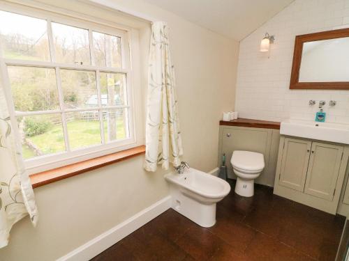 uma casa de banho com um WC, um lavatório e uma janela em Covercote em Leyburn