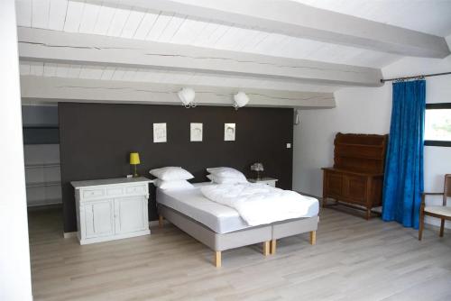 ein Schlafzimmer mit einem großen weißen Bett und einem Klavier in der Unterkunft Villa Luminières I in Sallelles