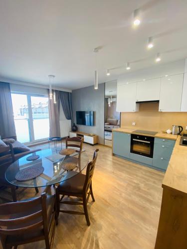 a kitchen and living room with a table and chairs at Apartamenty Białe nad jeziorem Białym in Augustów