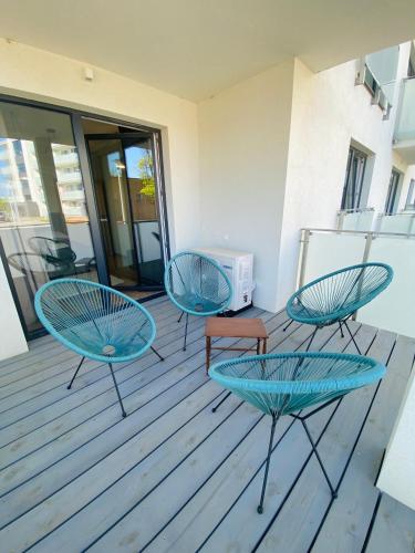 three blue chairs and a table on a deck at Apartamenty Białe nad jeziorem Białym in Augustów