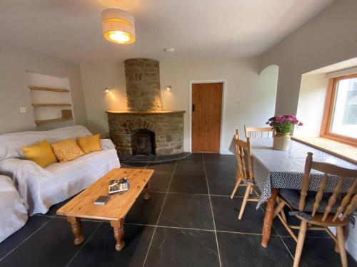 a living room with a couch and a fireplace at Oaktree Cottage, West Atheston Farm in Narberth
