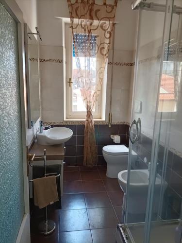 ein Bad mit einem Waschbecken, einem WC und einem Fenster in der Unterkunft Casa Vacanze Litoranea in Follonica