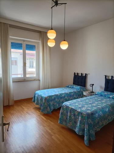 1 Schlafzimmer mit 2 Betten und einem Fenster in der Unterkunft Casa Vacanze Litoranea in Follonica