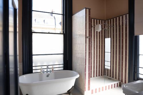 バースにあるMilsom Hotel Bathのバスルーム(バスタブ、窓付きシャワー付)