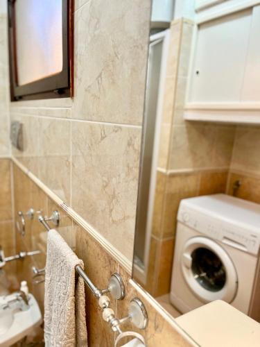 a bathroom with a washing machine and a sink at 20 steps from the beach VILLINO STECU in Costa Rei