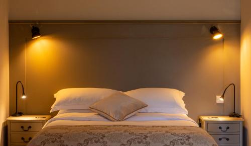 a bedroom with a bed with two nightstands and two lamps at Luxury Lodge @ Ewen Barn - private 5* retreat in Cirencester