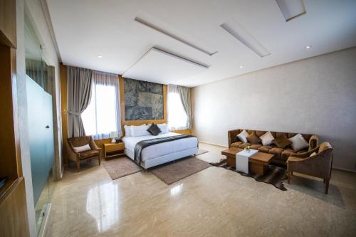 um quarto de hotel com uma cama e um sofá em Rim Aquatique Hôtel & Nature em Fez