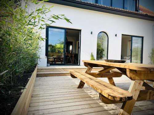 Villa Ô Wood & Chic في كوسيك: طاولة نزهة خشبية ومقعد على الفناء