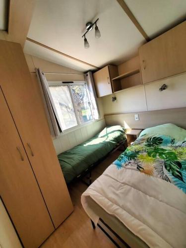Habitación pequeña con cama y ventana en Bungalow L'Estagnol - 3 chambres en Sigean