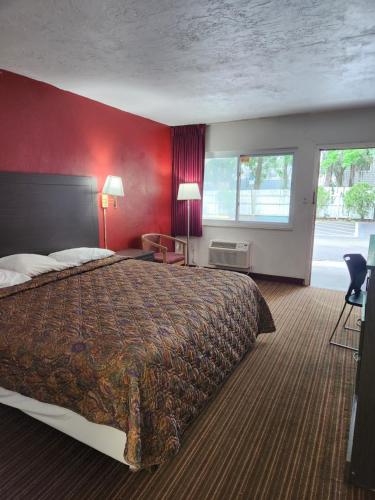 Habitación de hotel con cama y pared roja en regency inn, en Gainesville