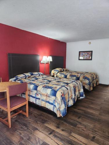 Habitación de hotel con 2 camas y mesa en regency inn, en Gainesville