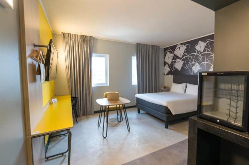 安托法加斯塔的住宿－ibis Styles Antofagasta，一间酒店客房,配有一张床铺、一张桌子和一台电视