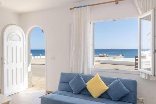 Sofá azul en la sala de estar con vistas al océano en Casa Abril, en S'Algar