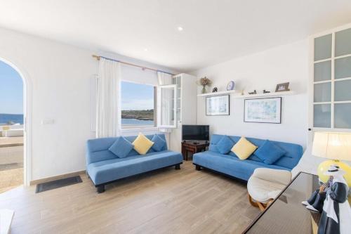 Sala de estar con 2 sofás azules y TV en Casa Abril en S'Algar