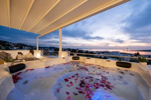 a hot tub on a balcony with a view of the ocean at Panos Villa Sunset View in Parikia