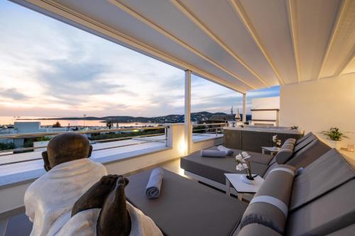 a man sitting on a couch in the living room of a house at Panos Villa Sunset View in Parikia