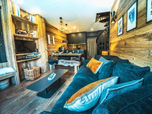un salon avec un canapé bleu et une table dans l'établissement Duplex rénové à Tignes · Proche pistes et commerces · Balcon · 6 pers · Wifi - FR-1-502-366, à Tignes