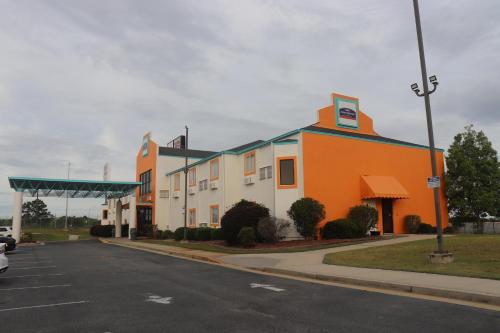 an orange and white building on the side of a street at Howard Johnson by Wyndham Tifton GA I-75 in Tifton