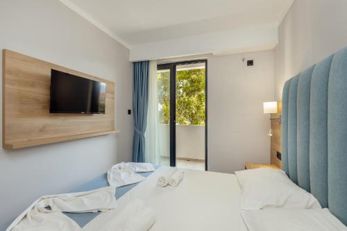 a bedroom with a bed and a tv on a wall at HOTEL TALIA in Herceg-Novi