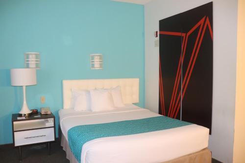 a bedroom with a bed with a blue wall at Howard Johnson by Wyndham Tifton GA I-75 in Tifton