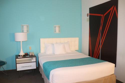 a bedroom with a bed with a blue wall at Howard Johnson by Wyndham Tifton GA I-75 in Tifton