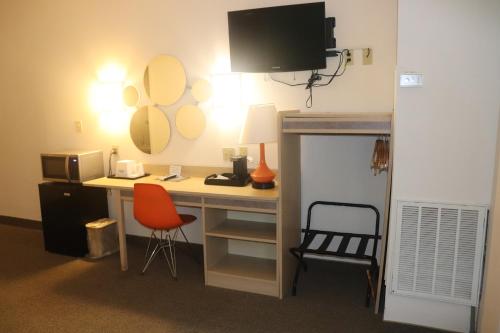 a room with a desk with a chair and a mirror at Howard Johnson by Wyndham Tifton GA I-75 in Tifton