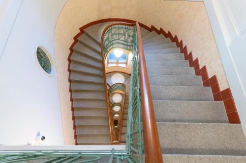 eine Wendeltreppe in einem Gebäude mit einem Glasgeländer in der Unterkunft numa I Laurel in Prag