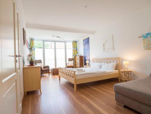 Un dormitorio con una cama, un escritorio y un sofá. en Appartement Nr 7 im Sonnenbad, en Sassnitz