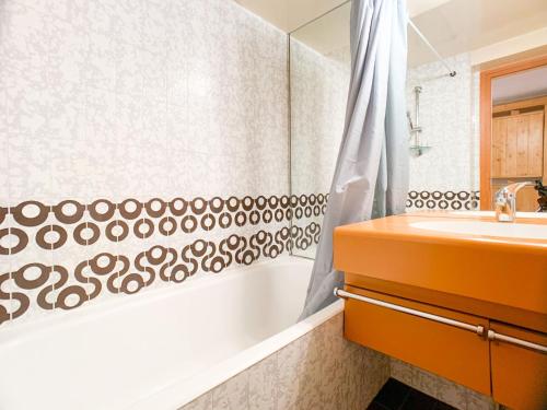 une salle de bain avec un rideau de douche et un lavabo dans l'établissement Studio confortable et lumineux à Tignes Le Lac, au pied des pistes, proche commerces, balcon sud - FR-1-502-423, à Tignes