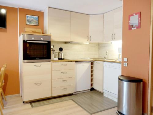 une cuisine avec des armoires blanches et un micro-ondes dans l'établissement Studio confort, balcon sud, au pied des pistes et commerces, animaux acceptés, Tignes Le Lac - FR-1-502-458, à Tignes