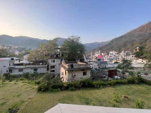 a group of buildings on a hill with a city at Hotel Manikut in Rishīkesh