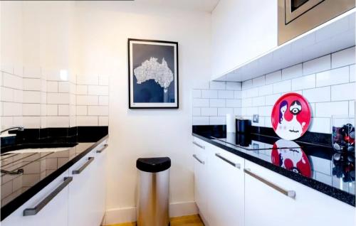 ロンドンにあるCentral London apartmentの黒と白のタイル張りの壁のキッチン