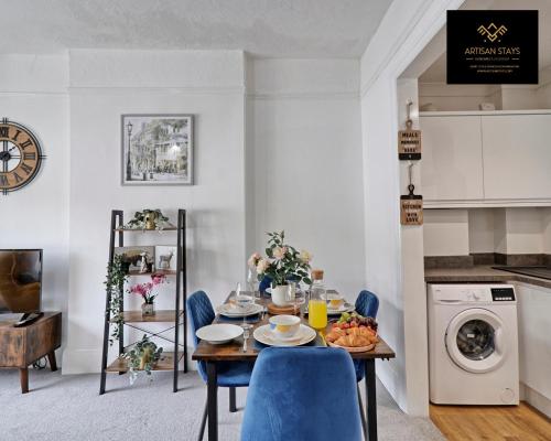 une salle à manger avec une table et des chaises bleues dans l'établissement Deluxe Apartment in Southend-On-Sea by Artisan Stays I Free Parking I Weekly or Monthly Stay Offer I Sleeps 5, à Southend-on-Sea