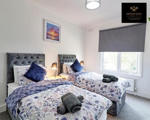 een slaapkamer met twee bedden met knuffels erop bij Deluxe Apartment in Southend-On-Sea by Artisan Stays I Free Parking I Sleeps 5 in Southend-on-Sea