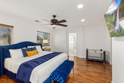 - une chambre avec un lit bleu et un ventilateur de plafond dans l'établissement Paradise private resort with waterfall pool, à Coachella