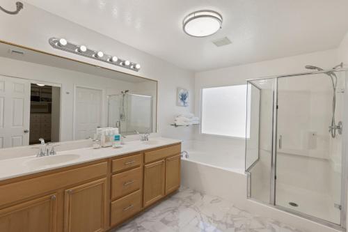 La salle de bains est pourvue de 2 lavabos et d'une douche. dans l'établissement Paradise private resort with waterfall pool, à Coachella