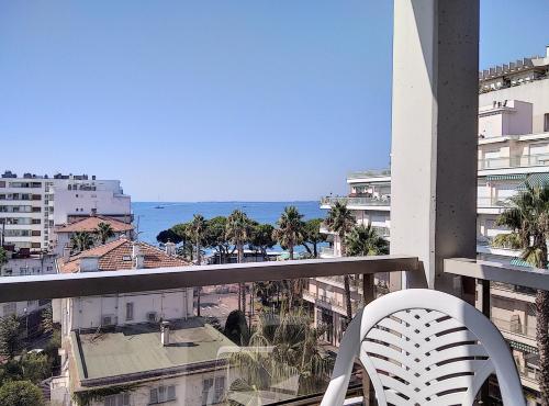 d'un balcon avec une chaise blanche et une vue sur l'océan. dans l'établissement Résidence Graziella Appartement 522, à Juan-les-Pins