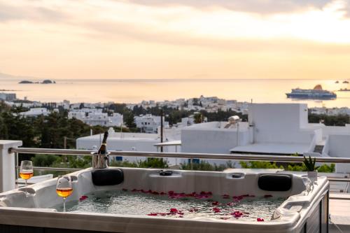 a hot tub on the balcony with two glasses of wine at Panos Villa Sunset View in Parikia