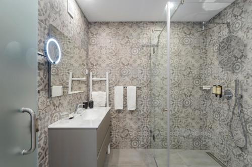 uma casa de banho com um chuveiro, um lavatório e um espelho. em Casa Sol 9 by Sevencollection em Carvoeiro
