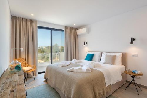 a bedroom with a large bed and a large window at Casa Sol 9 by Sevencollection in Carvoeiro