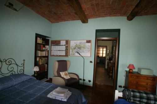 a bedroom with a bed and a chair and a book shelf at Antiche Mura in Avigliana